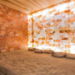 a bed sitting in the middle of a room next to a wall made out of bricks