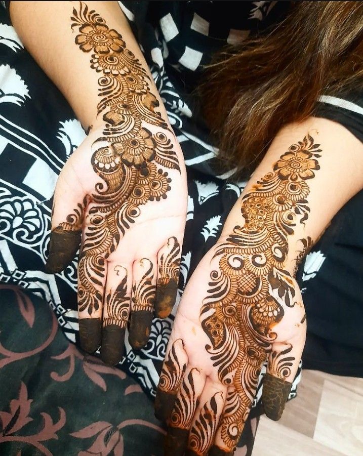 two hands with henna designs on them