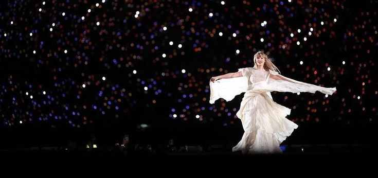 a woman in a white dress is dancing on stage