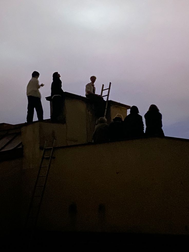 some people are standing on top of a building