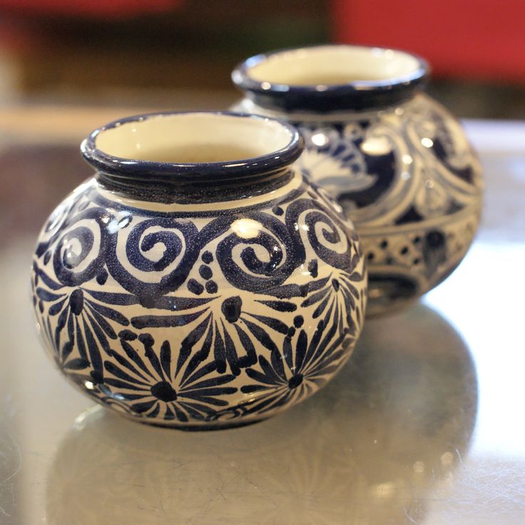 two blue and white vases sitting on top of a table