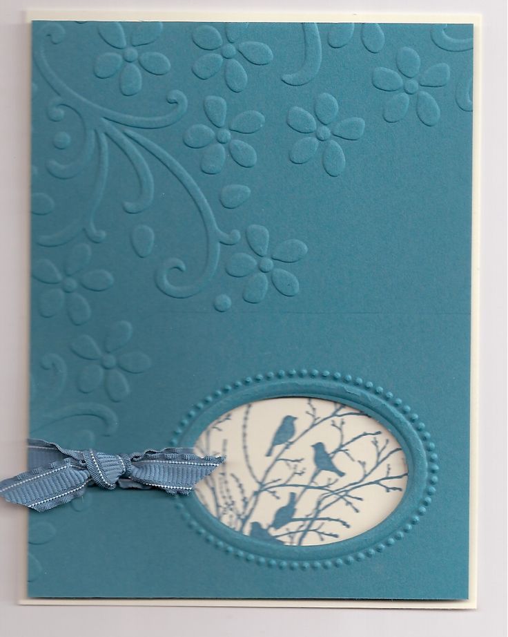 a close up of a greeting card with a bird on the tree and blue ribbon