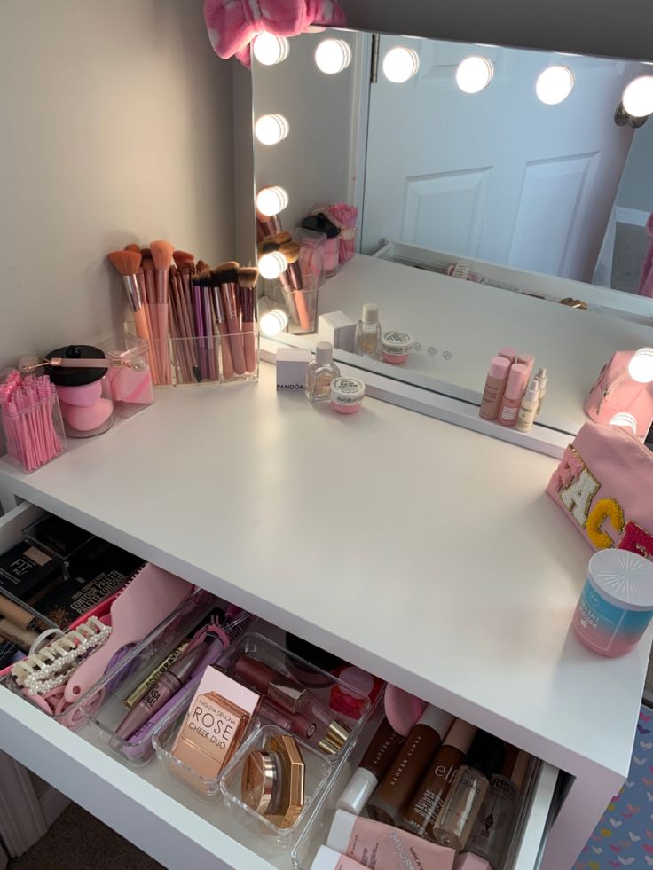 the vanity is full of cosmetics and makeup products, with lights on it's sides