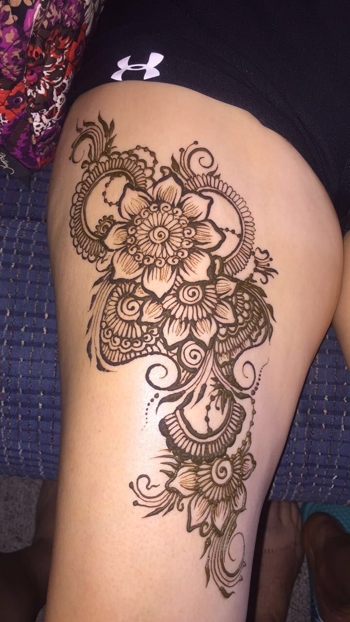 a woman's thigh with an intricate tattoo design on the side of her leg