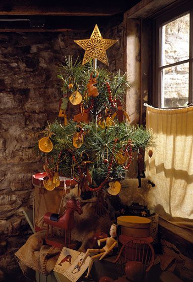 a small christmas tree in a room next to a window with decorations on the windowsill