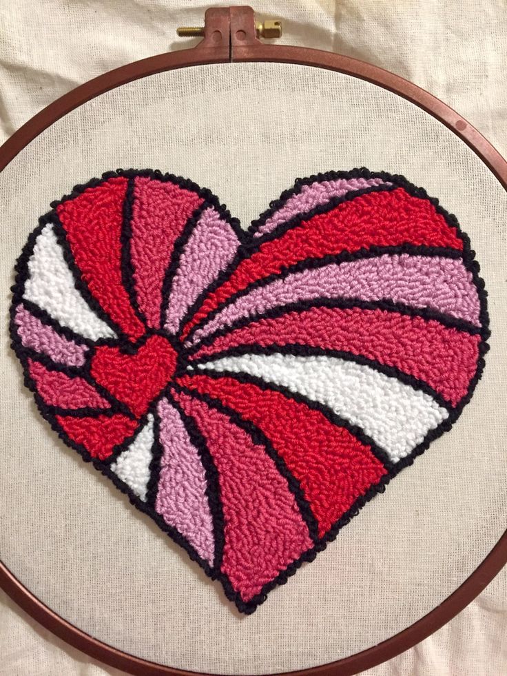 the heart is made up of red, white and pink yarn