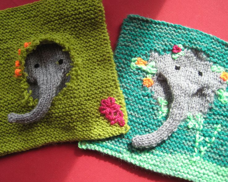 two crocheted square shaped like elephants on top of a red table with pink and green background