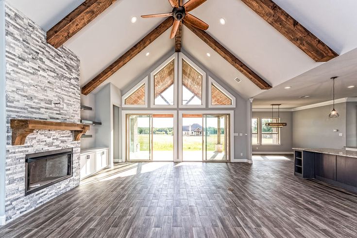 an empty living room with wood flooring and vaulted ceiling