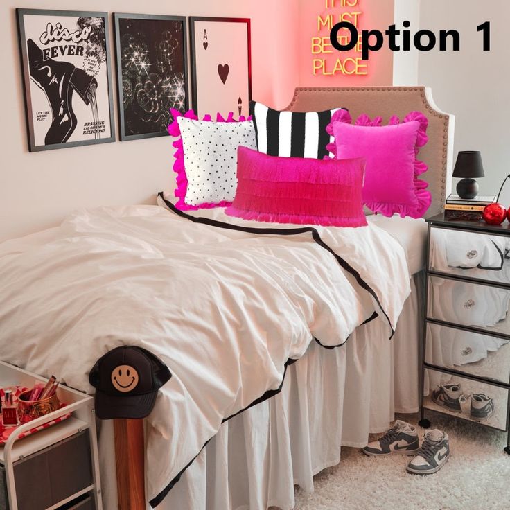 a bed with pink and black pillows in a bedroom next to pictures on the wall