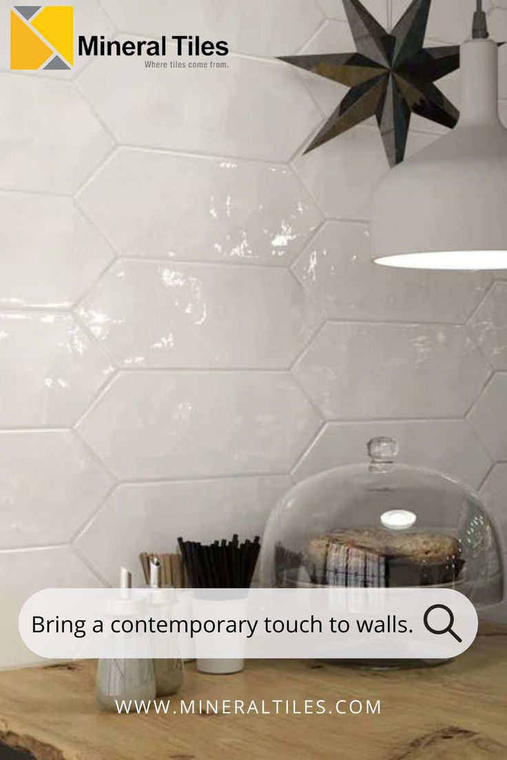 a wooden table topped with a glass container filled with books and other items next to a star shaped light fixture