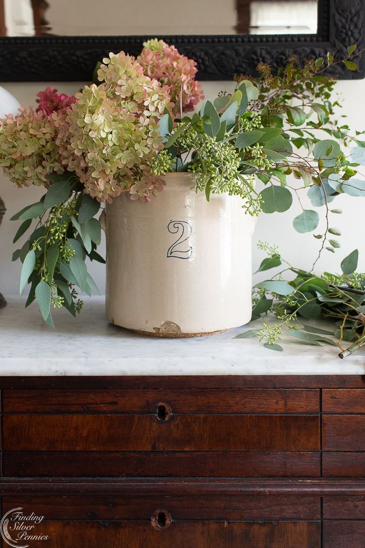 a vase filled with flowers sitting on top of a dresser