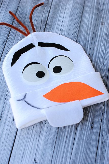 a snowman hat that is on top of a wooden table with eyes and nose