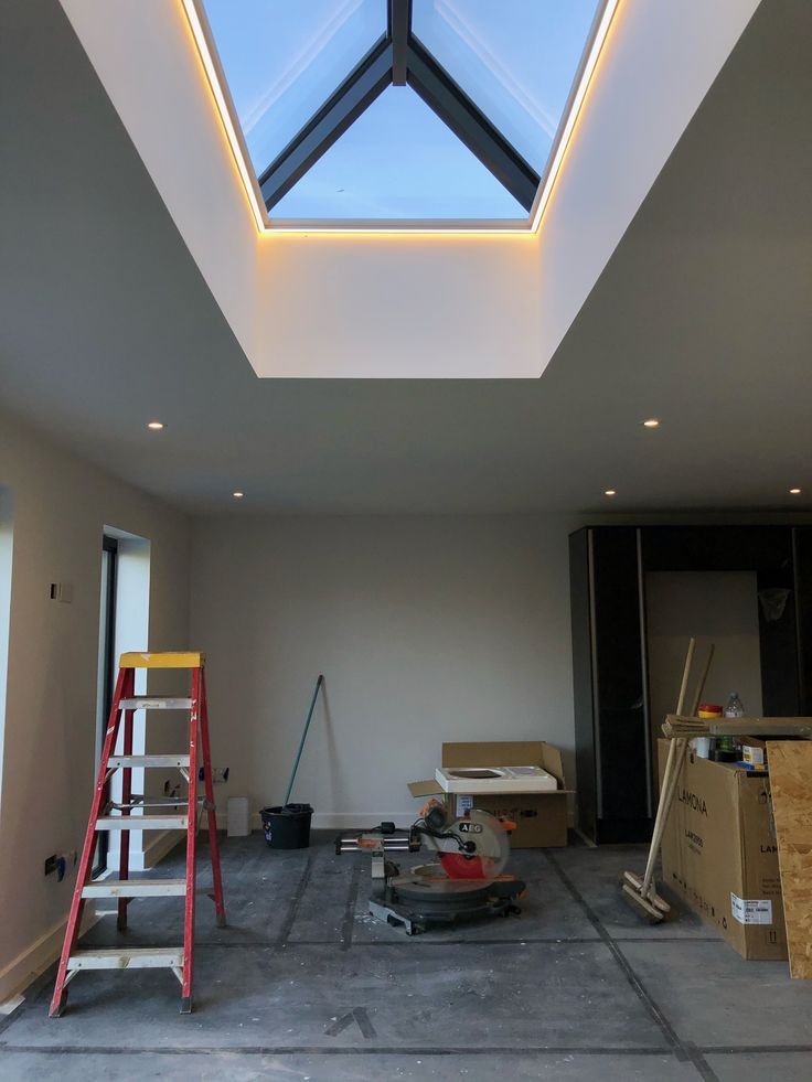 an unfinished room with a skylight and ladder