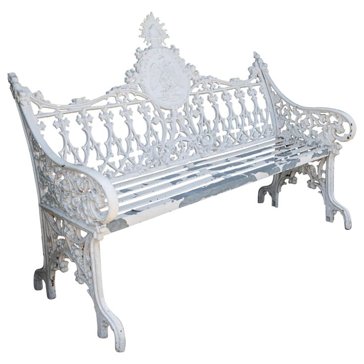 a white metal bench with ornate carvings on the back and sides, against a white background