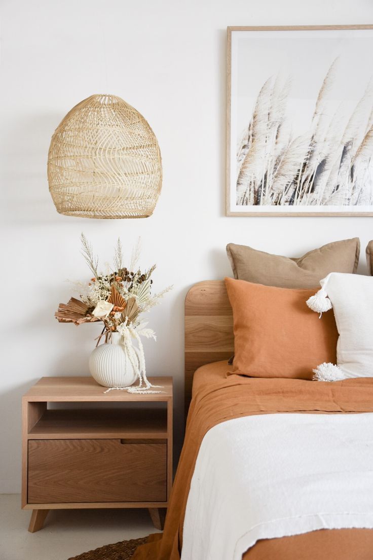 a bed room with a neatly made bed and a basket hanging above the headboard