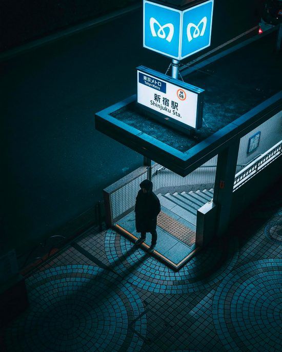 a person standing in front of a bus stop with a sign on it's side