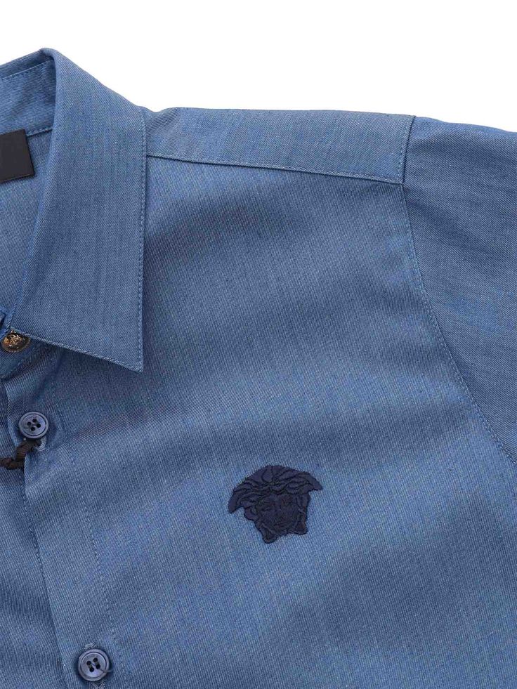 Blue shirt with Medusa embroidery on the front, short sleeves, classic collar, front buttons.Composition: 100% Cotton Embroidery 20% Polyester 80% Viscose Short Sleeve Embroidered Shirt For Work, Designer Short Sleeve Tops With Placket, Designer Blue Shirt With Button Closure, Blue Embroidered Short Sleeve Shirt, Fitted Short Sleeve Shirt With Embroidered Logo, Fitted Short-sleeve Shirt With Embroidered Logo, Classic Embroidered Short Sleeve Shirt, Medusa Embroidery, Versace Shirts