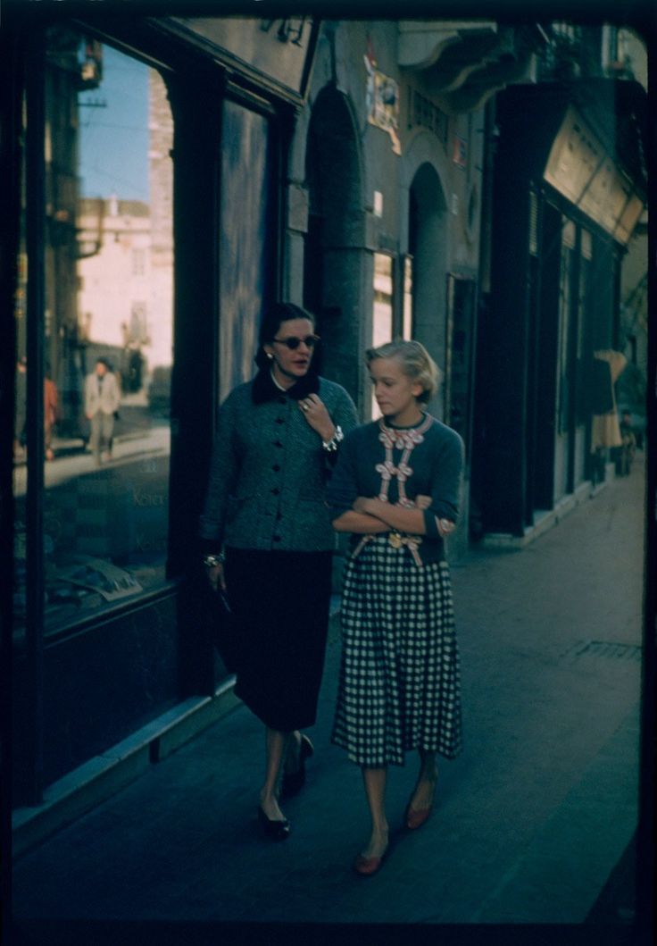 two women are walking down the street together