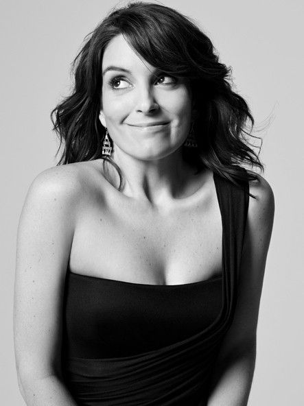 a black and white photo of a woman in a strapless dress smiling at the camera