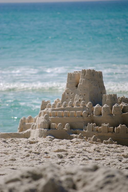 a sand castle sitting on top of a sandy beach