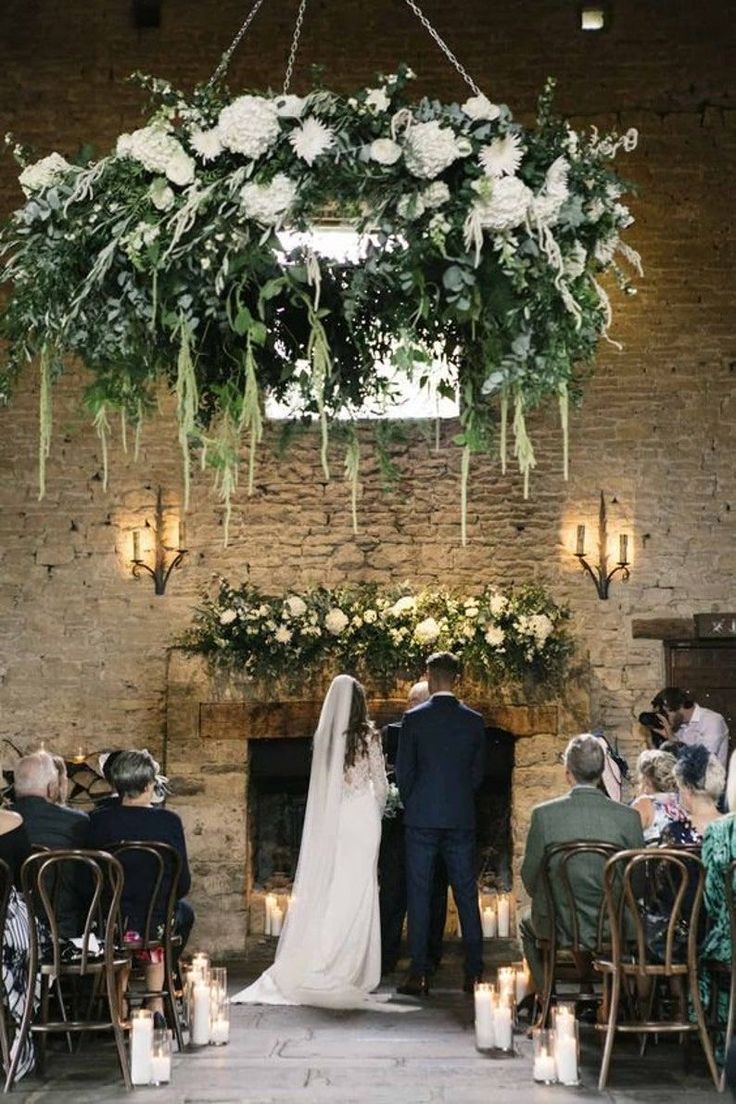 a bride and groom are standing in front of the fire place at their wedding ceremony