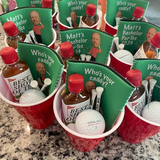 several cups filled with condiments on top of a marble counter next to a sign that says who's your caddy?