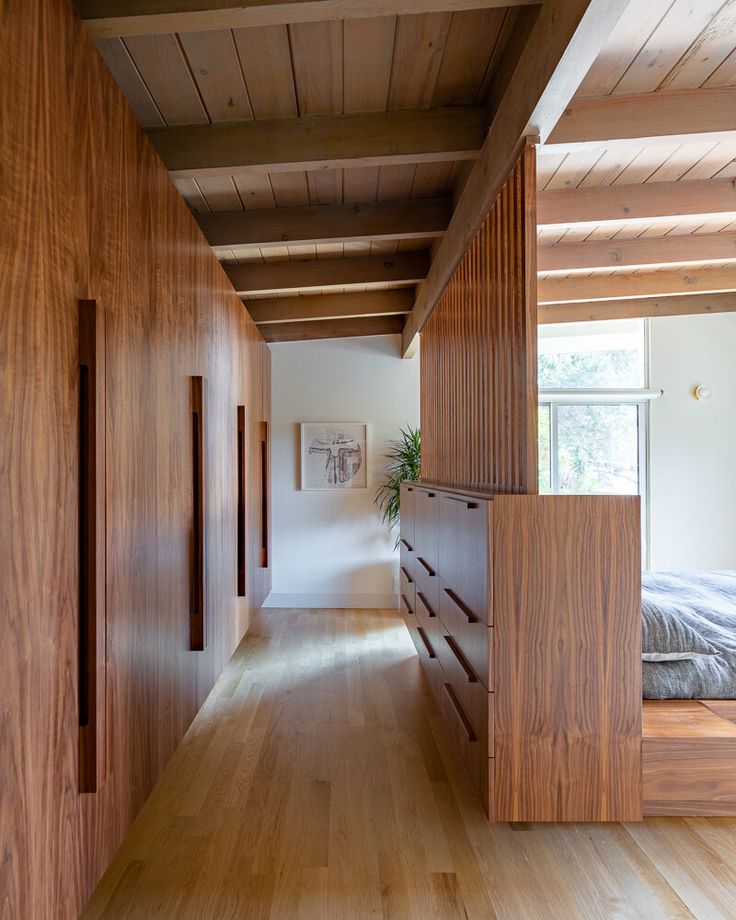 an empty bedroom with wooden walls and flooring