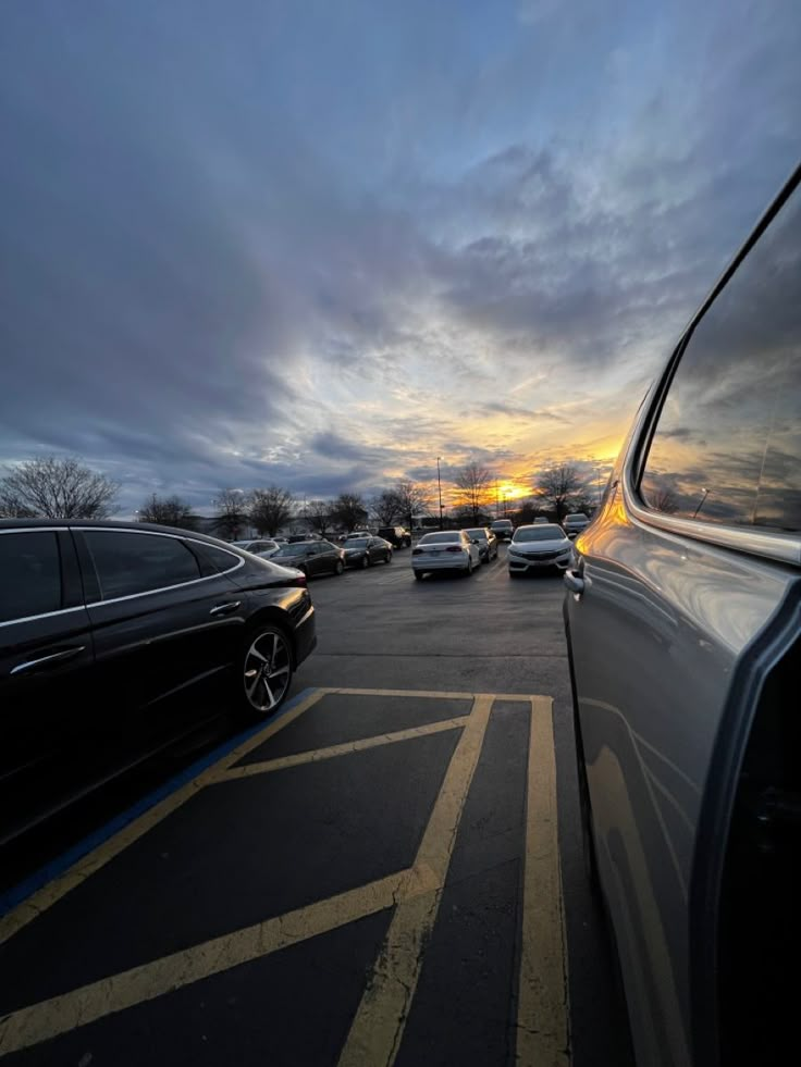 cars parked in a parking lot at sunset