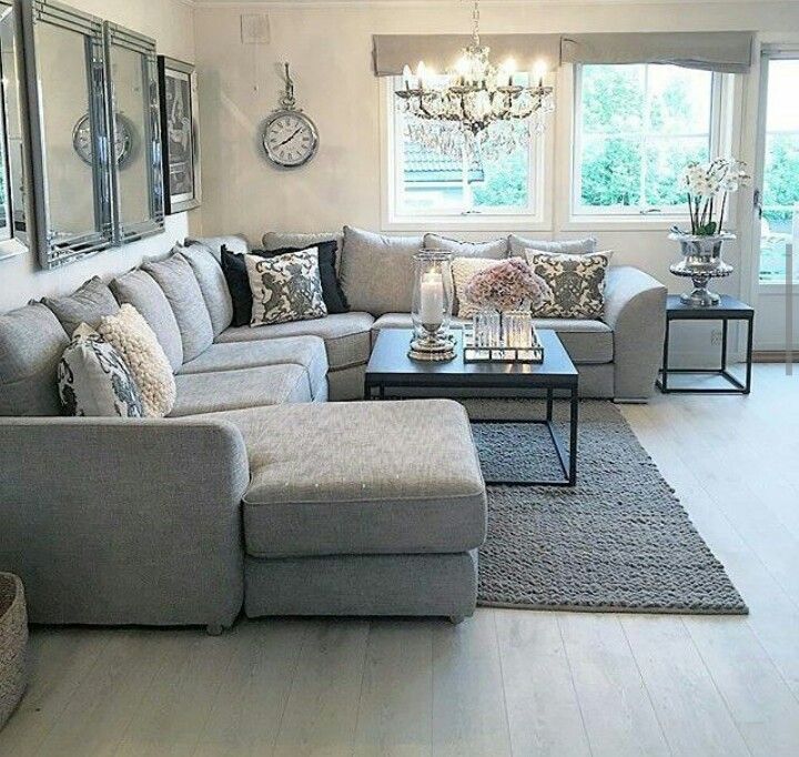 a living room filled with furniture on top of a hard wood floor covered in white walls