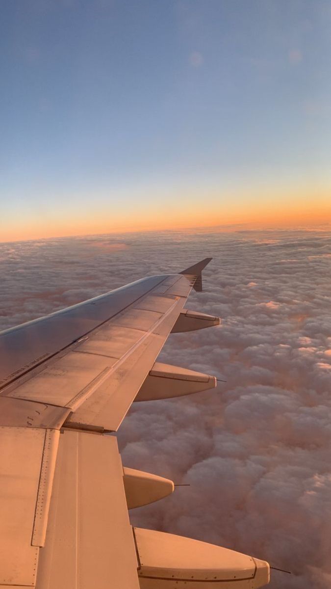 the wing of an airplane as it flies over clouds