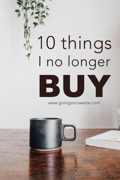 a black coffee mug sitting on top of a wooden table next to a wall with the words 10 things i'm no longer buy