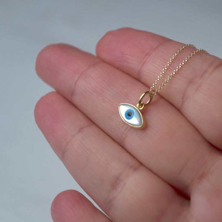 Εxtra tiny 14k solid gold evil eye pendant.  The pendant measures 11mm / 0.4 inches The evil eye pendant is available in 14k yellow gold with a white evil eye.  The  eye is made of mother of pearl (mop). The backside is closed, smooth 14k solid gold. Available with a solid 14k gold chain or as pendant only. Chains are available in 3 lengths, 16inches/40cm, 18inches/45cm and 20 inches/50cm Perfect gift for Valentine or any other special occasion. Comes in a gift box. Everyday Yellow Gold Evil Eye Charm Necklaces, White 14k Gold Round Charm Necklaces, White 14k Gold Round Charm Necklace, Dainty Yellow Gold Evil Eye Charm Necklace, Fine Jewelry Featuring Evil Eye, 14k Gold Evil Eye Charm Necklace, 14k Yellow Gold Evil Eye Charm Necklace, 14k Yellow Gold Evil Eye Jewelry, 14k Yellow Gold Jewelry With Evil Eye