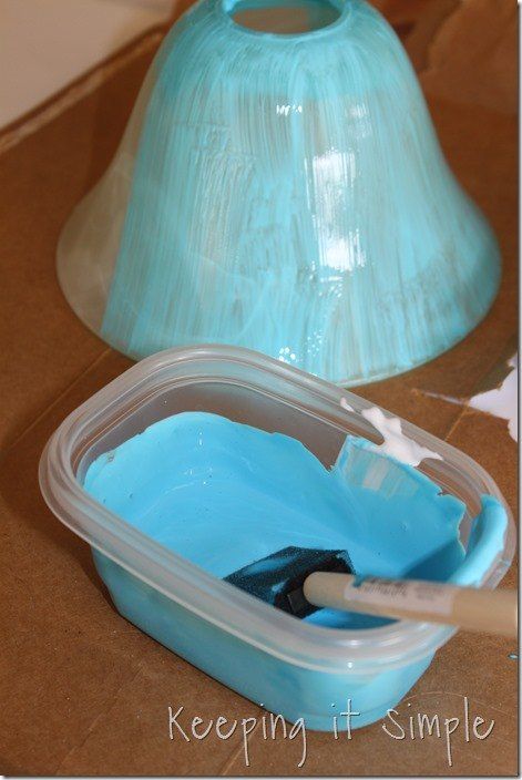 a plastic container with blue paint in it next to a paper towel on the table