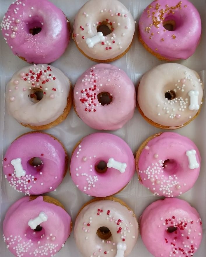 a box filled with pink and white donuts covered in sprinkles