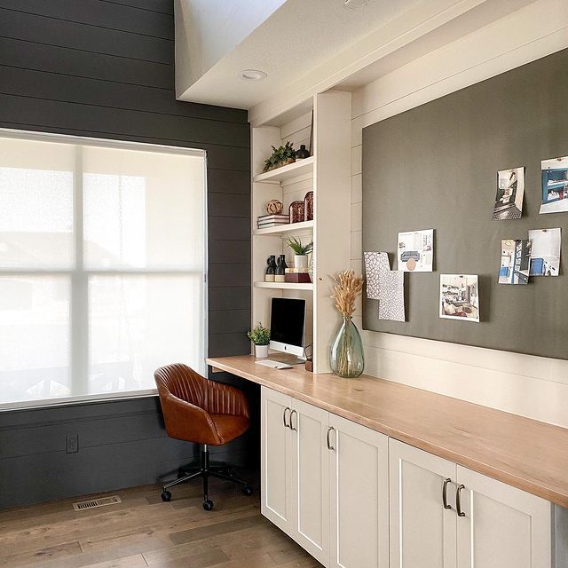 an office with white cabinets and brown leather chair in front of the desk is shown