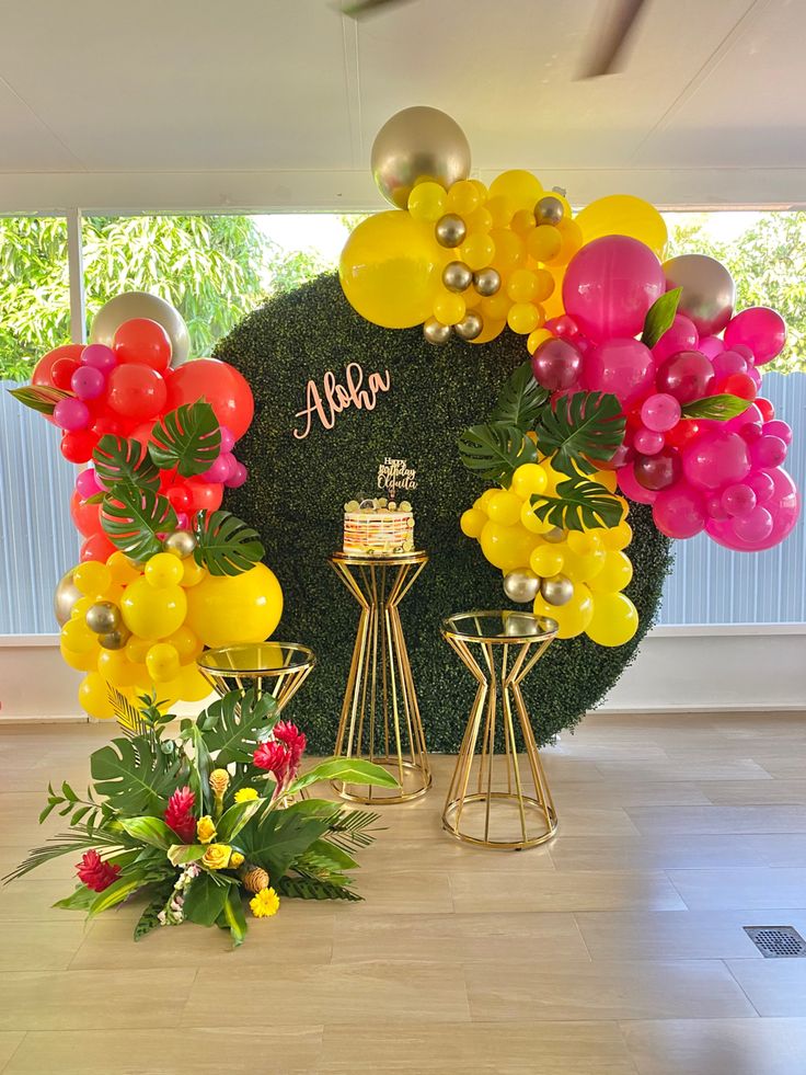 an arrangement of balloons and flowers on display