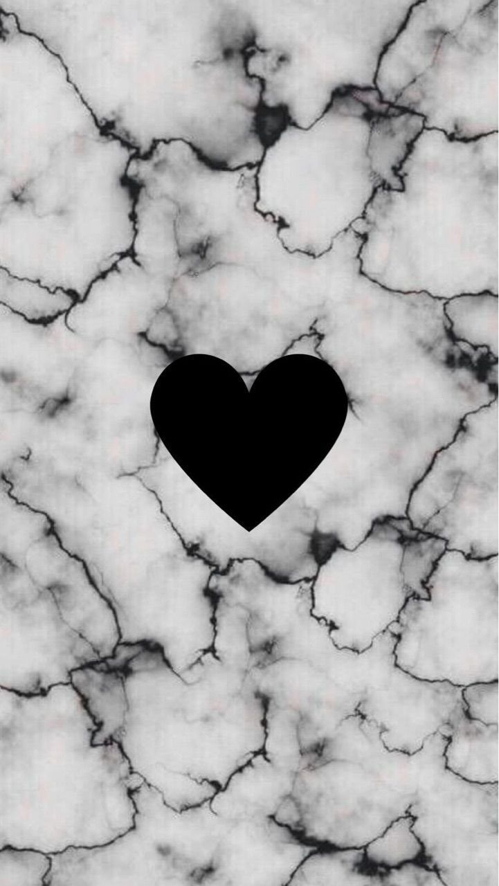 a black heart sitting on top of a marble floor