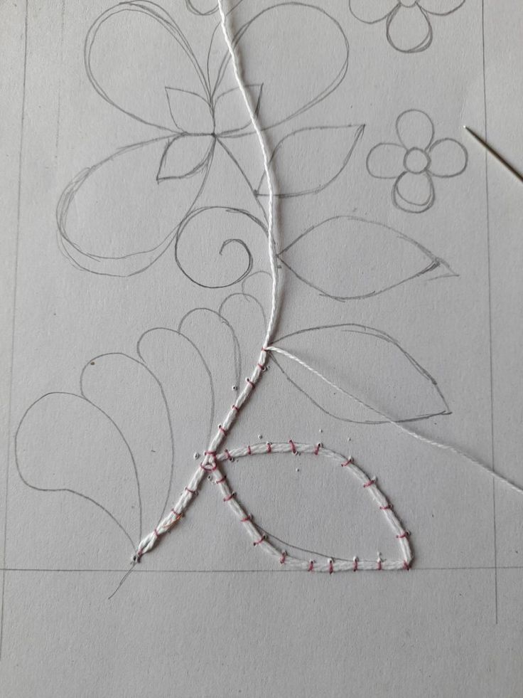 a piece of paper that has been drawn with scissors and thread on top of it