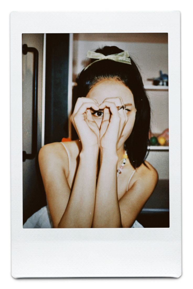 a woman covering her face with hands while sitting in front of a refrigerator freezer