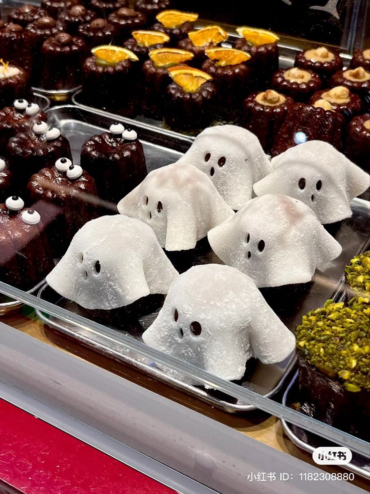 there are many halloween treats on display in the store window with white ghost heads and black eyes