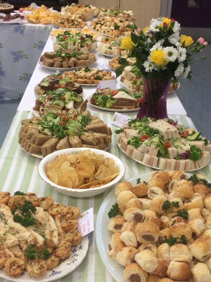 a table filled with lots of different types of sandwiches and pastries on white plates