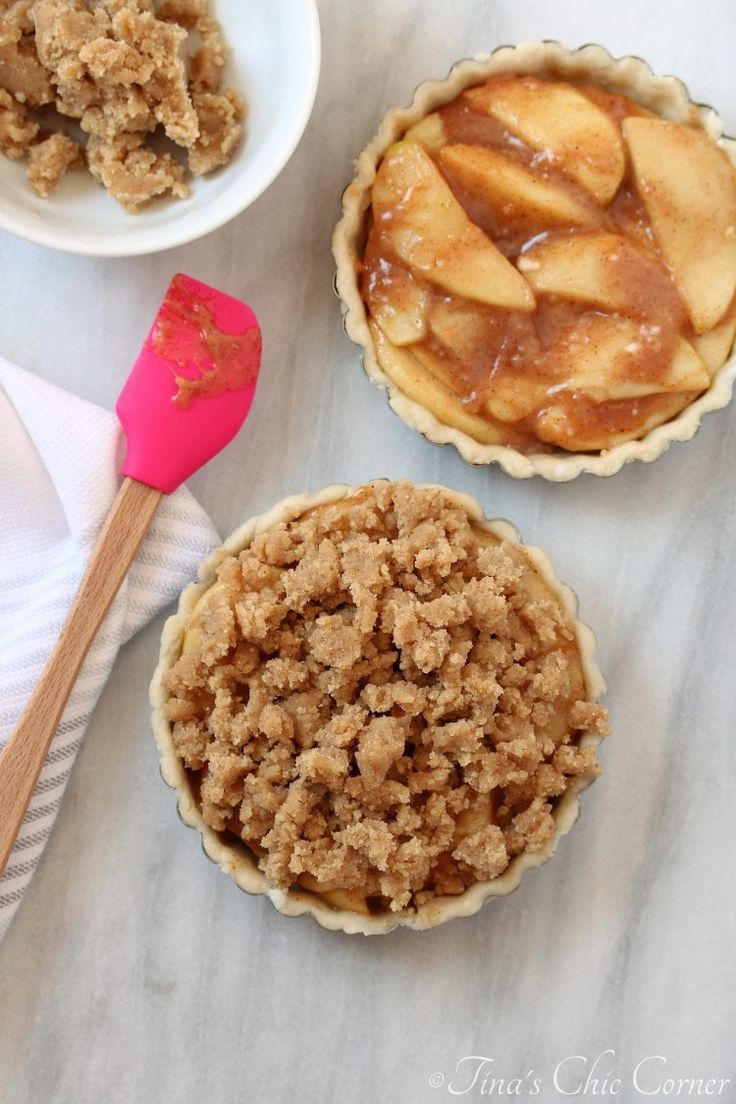 three pies with apples in them on a table