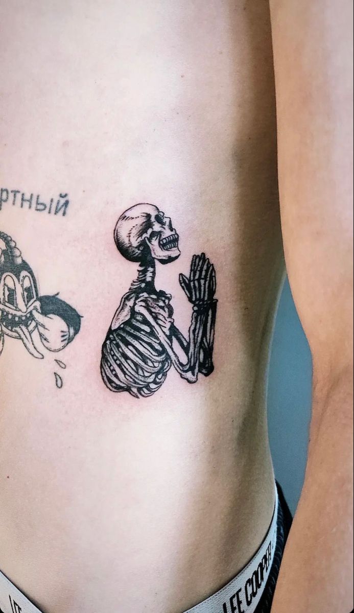 a woman's stomach with a skeleton tattoo on it and a motorcycle in the background