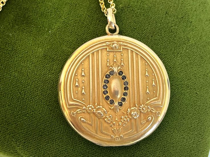 "Description: A large and lovely antique round Art Nouveau monogrammed gold filled photo locket on a new 14K gold filled chain.  The front of this locket made by the SB Company, features a central raised oval shape surrounded by a total of 14 \"paste\" stones. The stones that were probably once clear have darkened with age. There are 7 in paste gems on each side of the central oval. At the top and at the bottom of this oval shape is a raised fleur de lis. There are a total of 6 raised vertical l Heirloom Oval Link Locket Necklace, Ornate Oval Locket Necklace, Antique Engraved Oval Locket Necklace, Victorian Antique Gold Oval Locket Necklace, Victorian Oval Brass Locket Necklace, Round Art, Photo Locket, Antique Art Deco, Gold Filled Chain