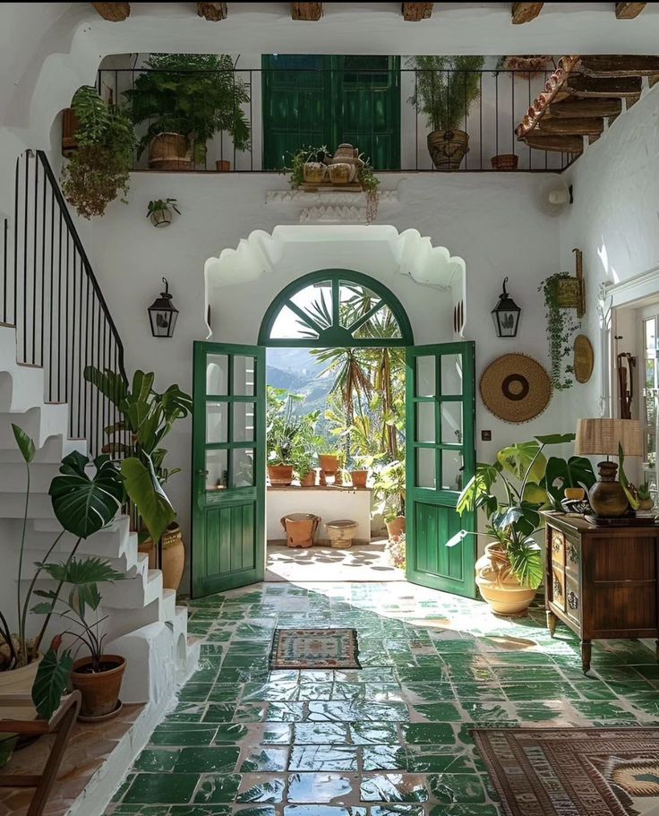 an entry way with green doors and potted plants