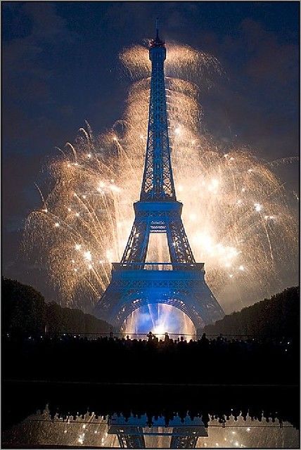 the eiffel tower is lit up with fireworks