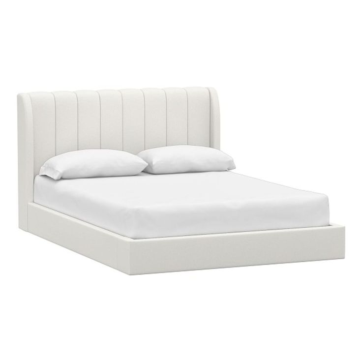 a bed with white sheets and pillows on it