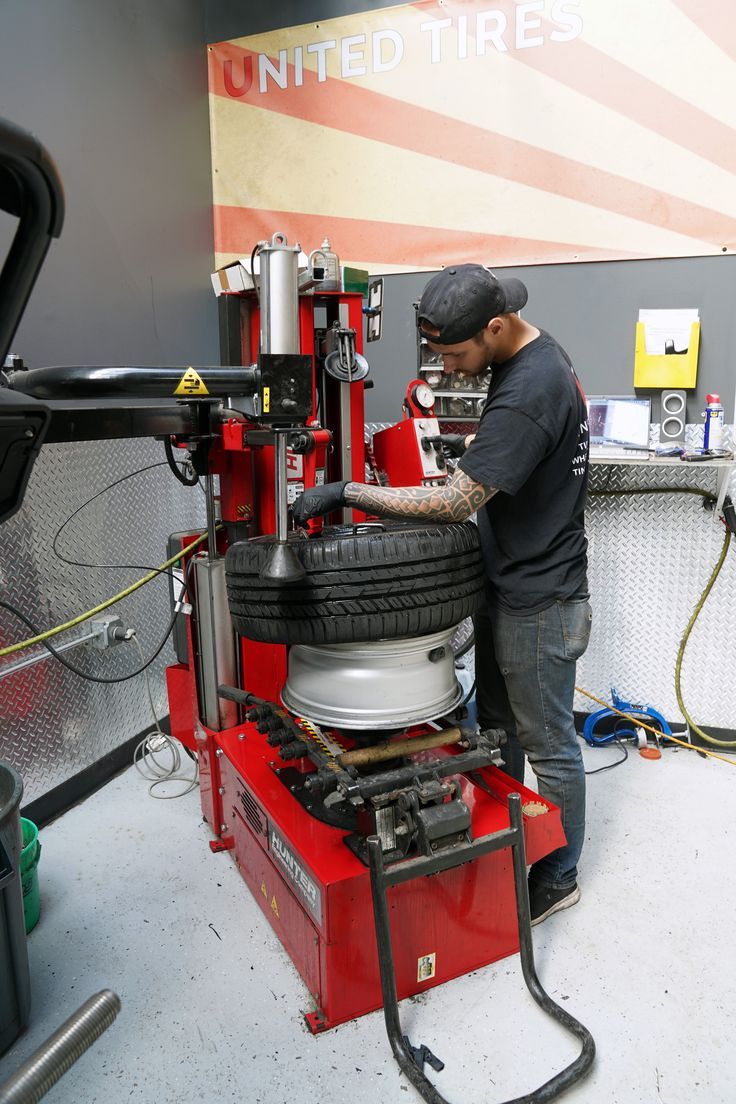 a man working on a tire in a garage