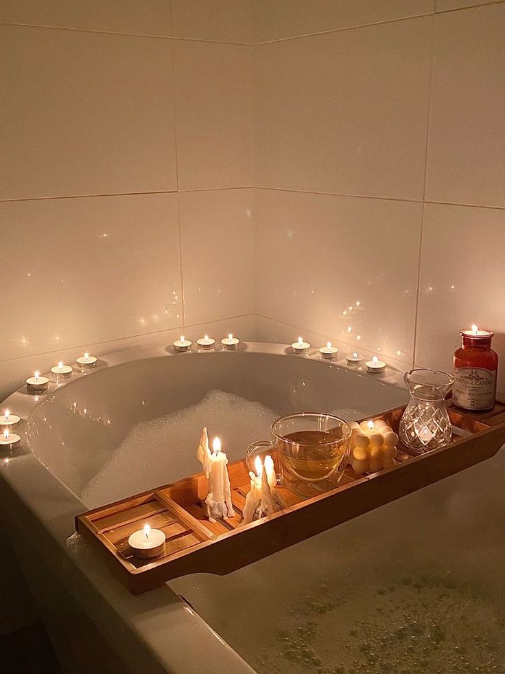 a bathtub with candles and tea lights in it