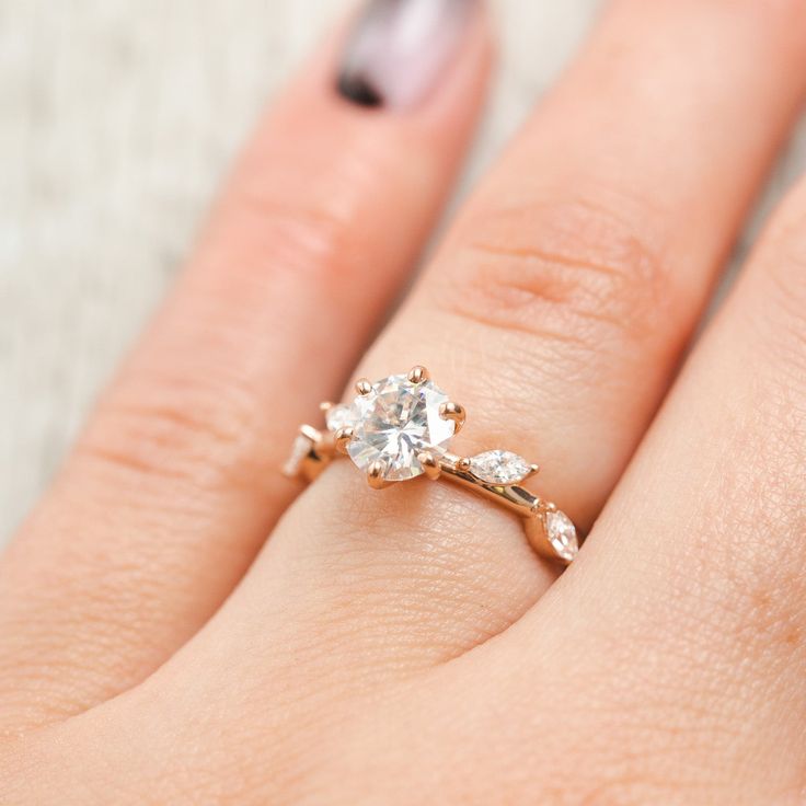 a woman's hand with a ring on it and a diamond in the middle